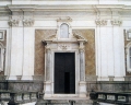 -Portal in white Carrara marble made by Bernardo Landini in 1647, surrounded by Corinthian columns and arched tympanum with aedicule inserted.   
